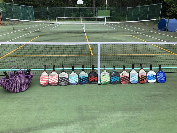 Pickleball court with plenty of paddles available.