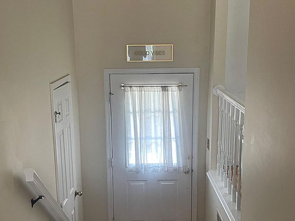 Front hallway. Door on the left is the powder room and open space looks into kitchen.
