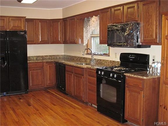 Kitchen with granite countertops, new refrigerator, dishwasher and microwave.