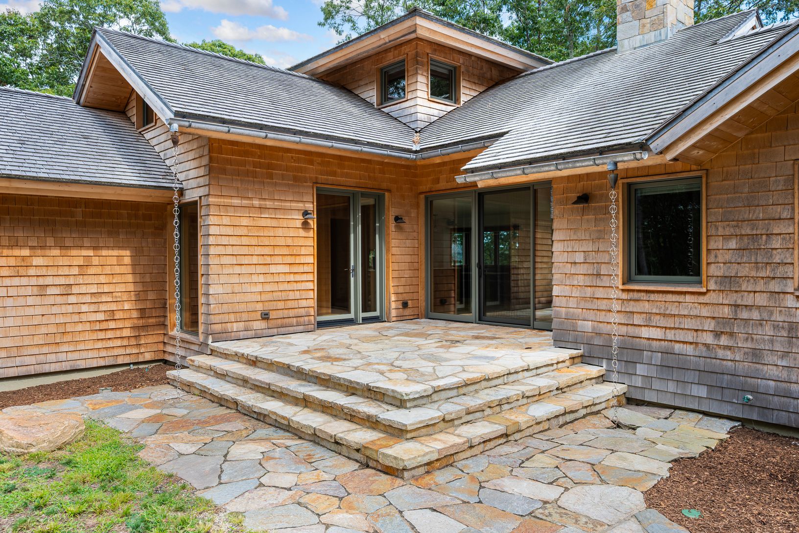  Steps to flagstone patio leads to entrance and sliding doors to living room