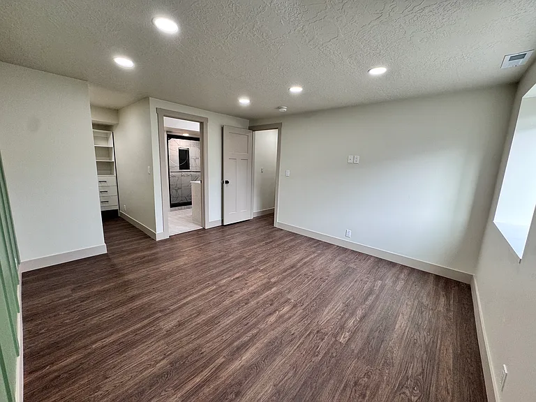 Spacious master bedroom with abundant natural light, modern finishes, and a comfortable, open layout.
