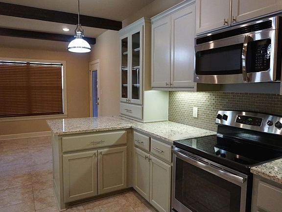 Kitchen and dining area with door to privately fenced backyard