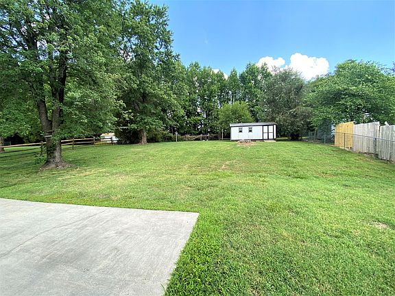 Large back yard with fence and storage shed.