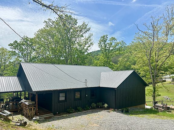 Front view; home overlooks small lake and pasture in quiet setting