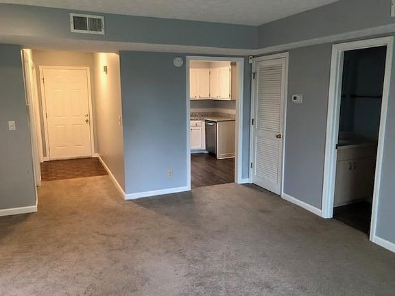 Den looking into kitchen and half bath on right. Coat closet and laundry closet down hall on left.