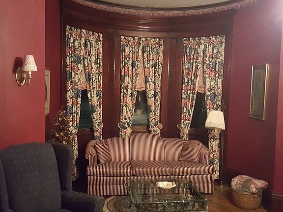 Front Parlor / Living Room : View of turret area. Home has custom made window treatments throughout