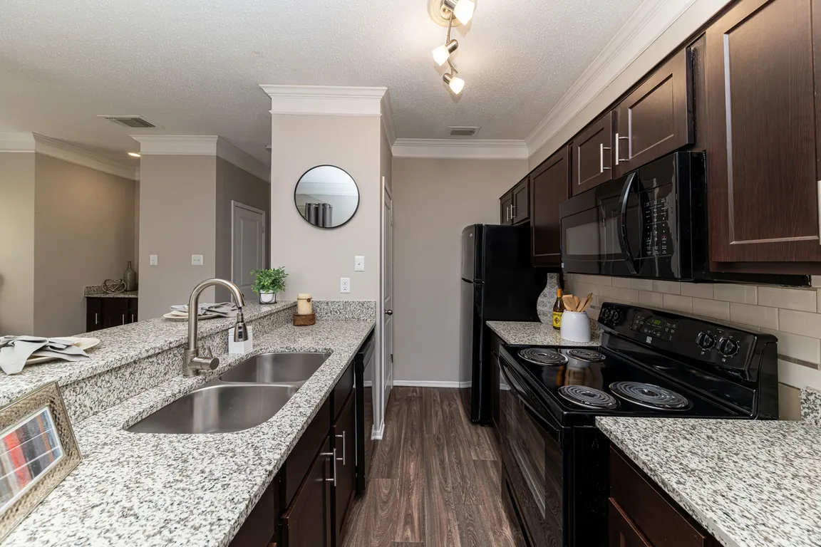 Kitchen with granite counters, black appliances, and modern cabinetry