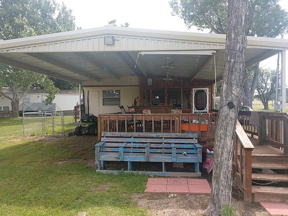 The lakeside of this lake home is where your whole gang will want to be! The fully covered deck features plenty of seating, a fun little bar area, and it's just steps to the water from here. The metal cover extends over your parking area, and there's even a PetSafe fence for the furry friends!