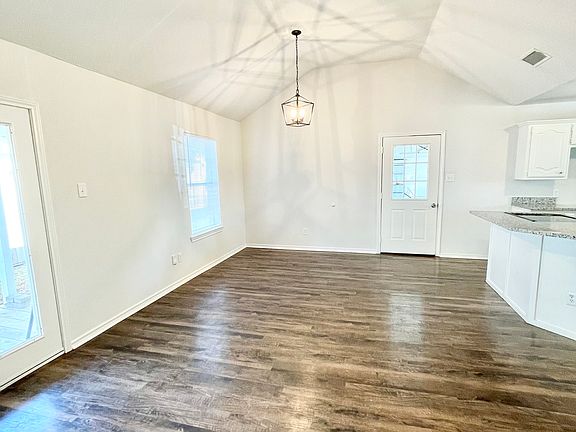 Open concept living and dining with vaulted ceiling.