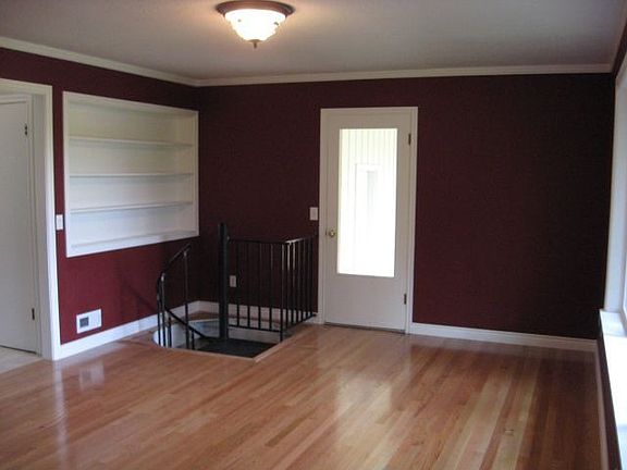 Another view of formal living room with built ins and door to backyard