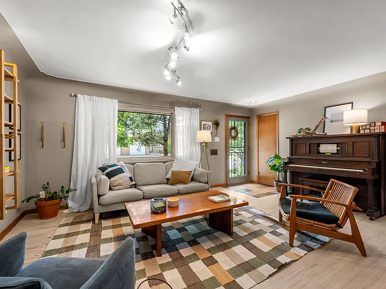 Living room with wood floors and coat closet by entry