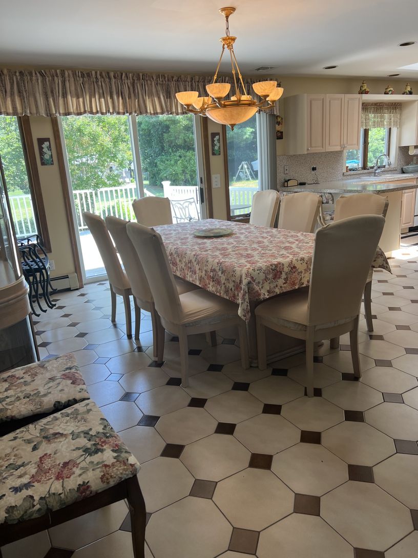 Dining room and sliding glass doors lead to a deck overlooking a large backyard.