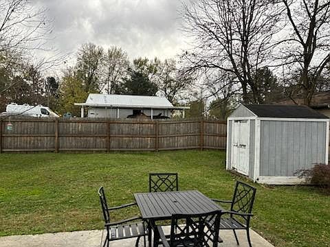 Backyard includes storage shed.