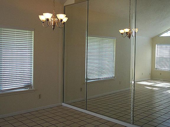 There is an adjoining formal dining room. Both rooms have a high ceiling and tile flooring.
