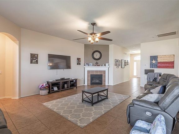Open living room w/ wood-burning fireplace.