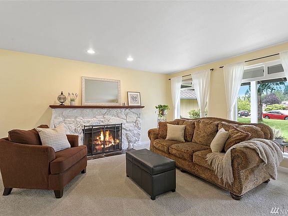 Cozy up to the wood burning fireplace in the living room. Notice all the light coming in from the wall of windows!