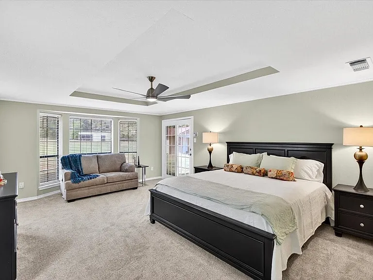 Showing a king size bed with 2 large bedside tables and oversized chest of drawers. New ceiling fans through out the home.