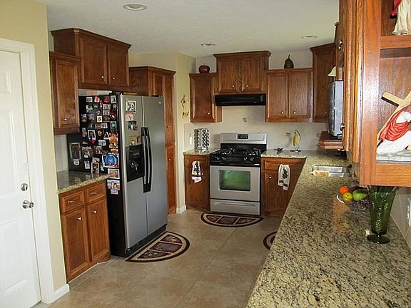 KITCHEN WITH GRANITE COUNTERS, STAINLESS APPLIANCES, TILE FLOORING, CUSTOM CABINETS AND RECESSED LIGHTING