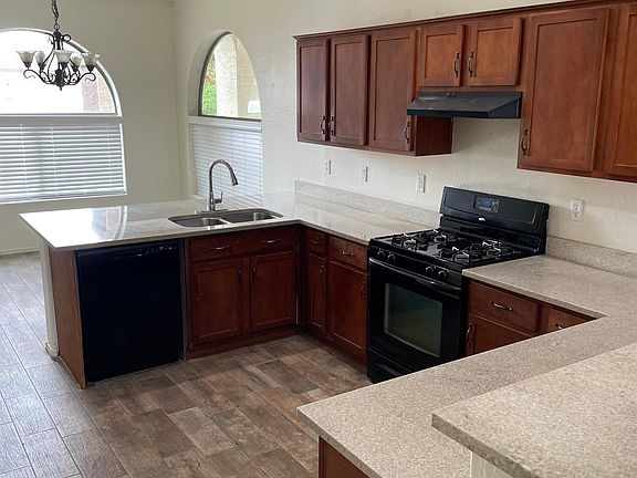 Spacious Kitchen with black appliances and granite countertops.