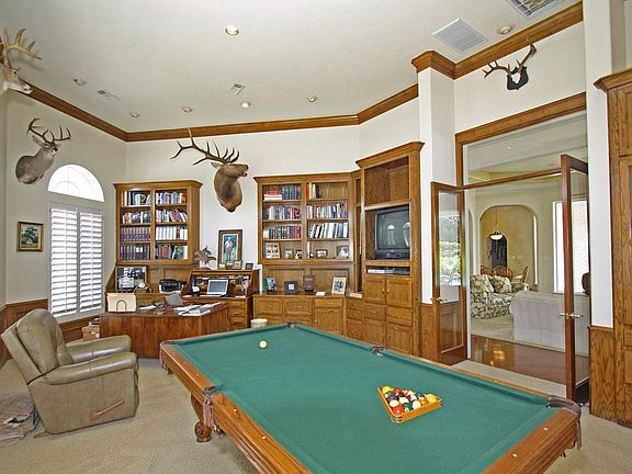 Amazing room with custom built-in shelving, file drawers & even gun cabinet.