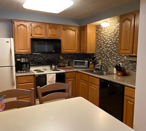 Kitchen equipped with dishwasher, microwave, refrigerator/freezer, stove, toaster, airfryer/toaster oven.