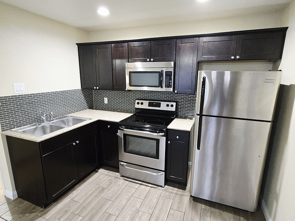 Kitchen with stainless steel appliances and modern glass backsplash tile with a espresso shaker kitchen cabinet