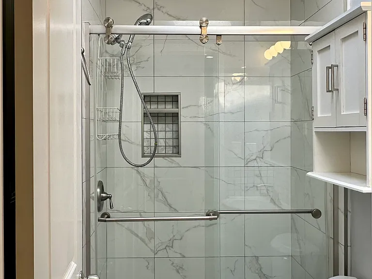 Full bathroom with walk-in shower and skylight