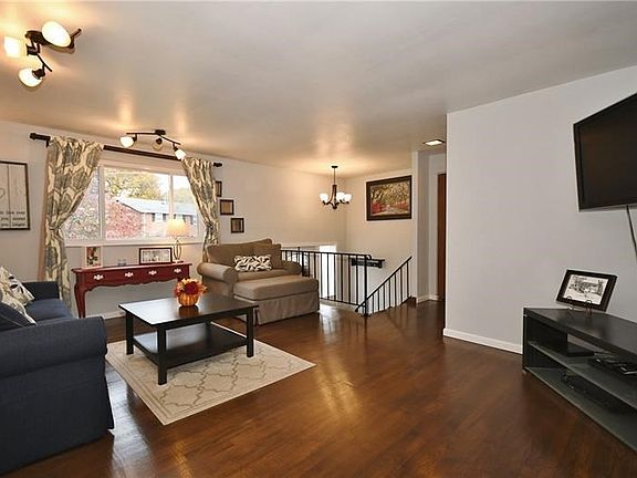 A large front window and fixtures provide light that beautifully illuminates the rich, dark hardwood floors.