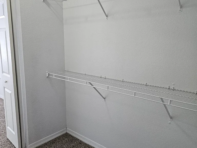 Generous walk-in closet with plenty of space for clothes, shoes, and accessories_designed for easy organization and accessibility.