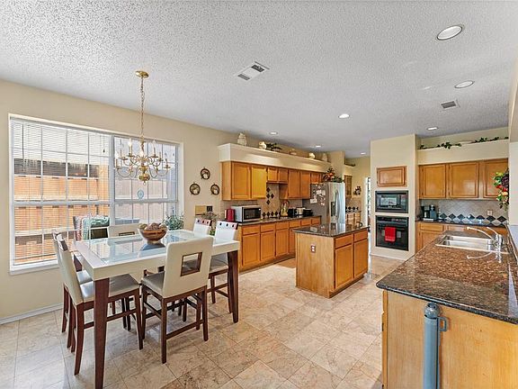 Dining area with a textured ceiling, a chandelier, and recessed lighting