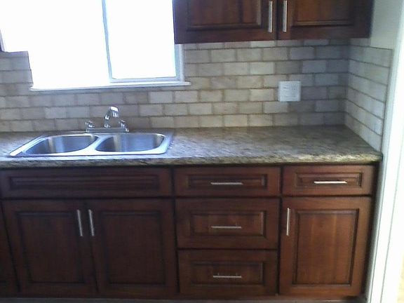 Newer cabinets,granite countertop,with travertine backsplash