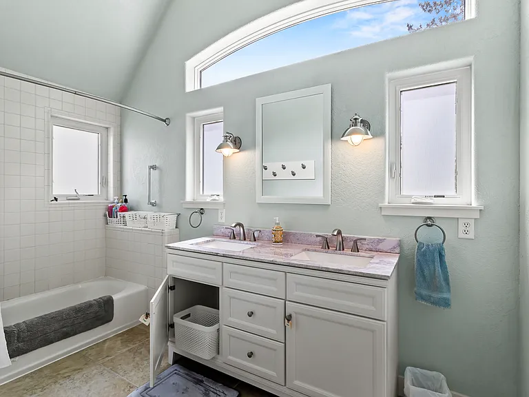 Shared bath. Water closet is adjacent to bath and is accessible to both shower room and to hallway. Caddy baskets for each room in shower