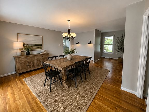Formal dining room featuring hardwood floors, abundant natural light, and a large sliding glass door that opens to the deck, creating the perfect space for both indoor and outdoor entertaining.