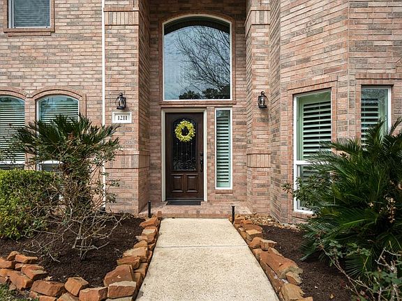 Classic brick elevation of the Traditional style of this Gleannloch Farms beauty has covered front porch. The exterior was repainted in 2020.