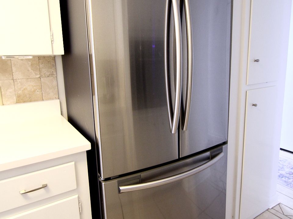 Kitchen has stainless French door refrigerator.