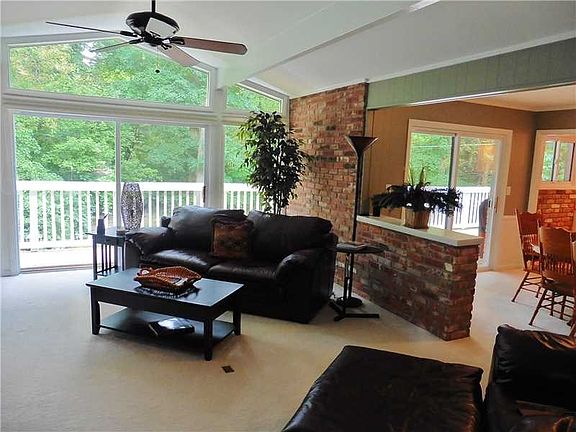Great Room. The Great room features a beamed vaulted ceiling, a ceiling fan, walls of brick, and sliding doors which open to the entertainment deck.  The views of the woods are great!