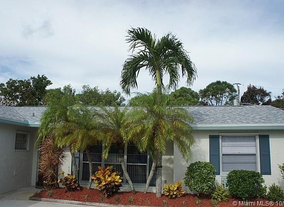 Beautifully landscaped planting area includes Phoenix Robellini Palms and colorful Crotons