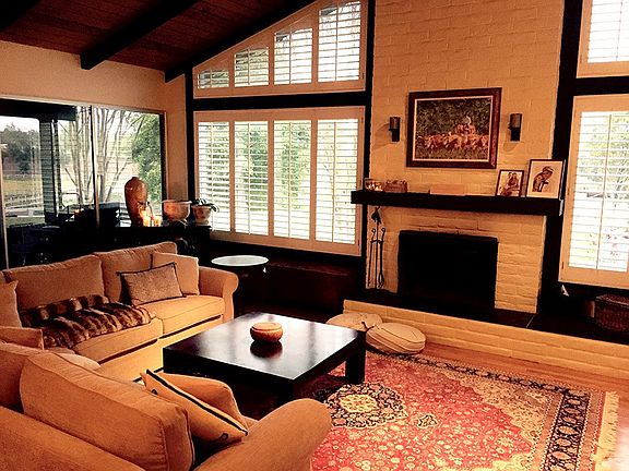 Sunken livingroom, brick fireplace, hardwood floors, plantat