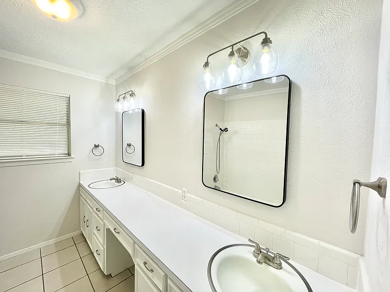 Hall bath with double sinks, new lighting, and hardware