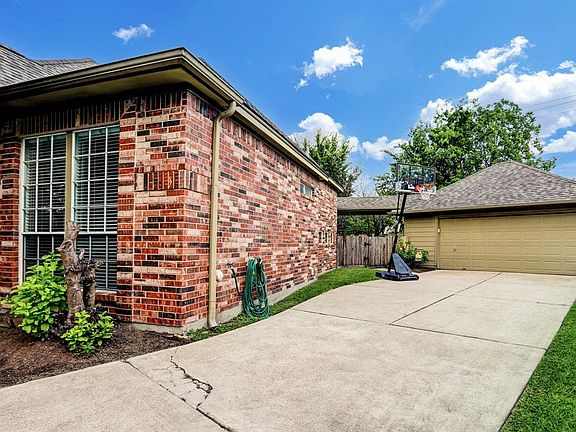 Home features extra LONG driveway, with detached garage and a covered walk way to the home!