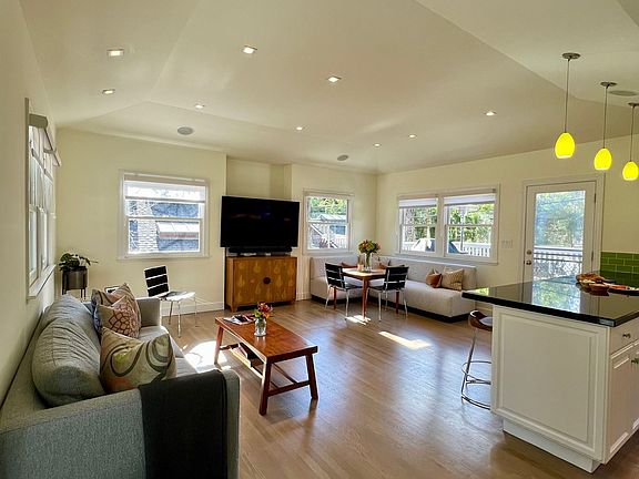 Family Room features a mounted large screen TV with Sonos sound system and doors to both front and back decks.