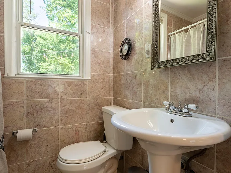 Bathroom with pedestal sink and tub shower combo.