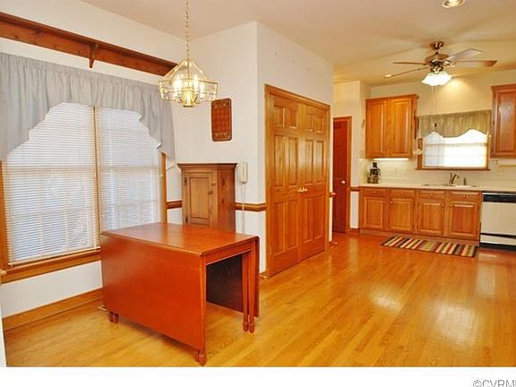 Eat-in kitchen with hardwood flooring.