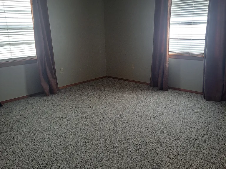 Bedroom has Berber carpet and lots of natural light.