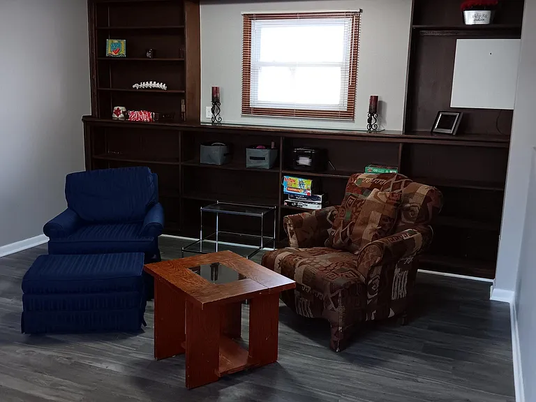 Large basement family room with built in shelving to play and relax.