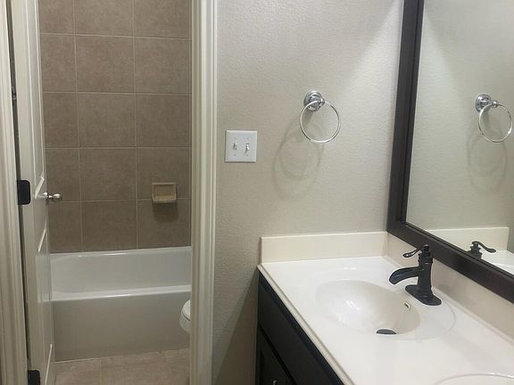 Second floor secondary bathroom with double sinks, toilet, shower and bathtub combo.