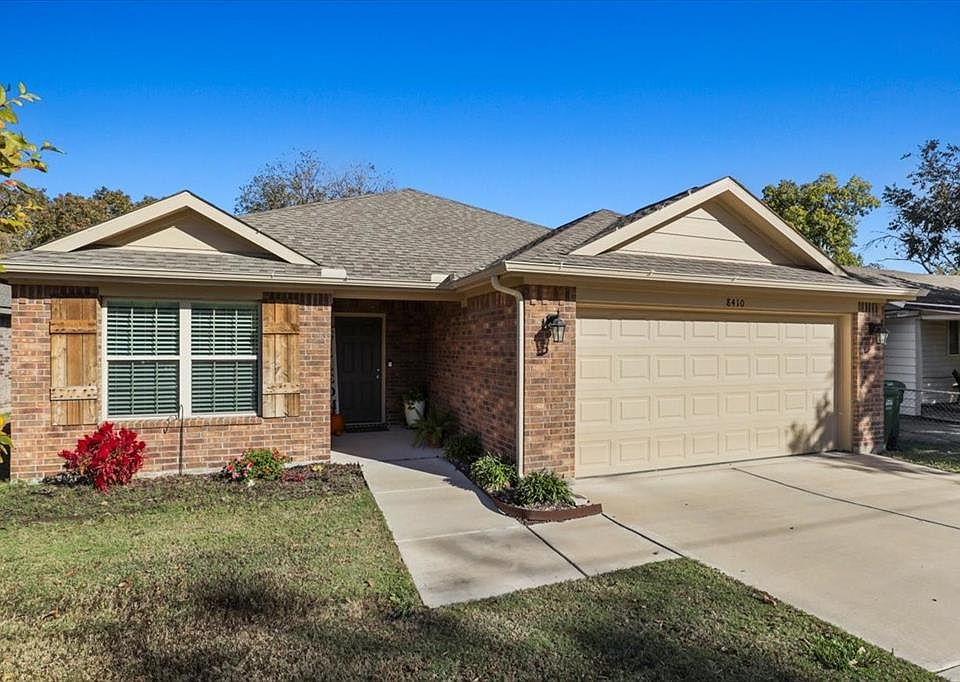 Ranch-style house featuring an attached garage, brick siding, a shingled roof, driveway, and a front yard