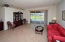 Living Room with plant shelf, crown molding, and tile flooring