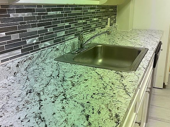 brand new stylish countertop and glass tile backsplash