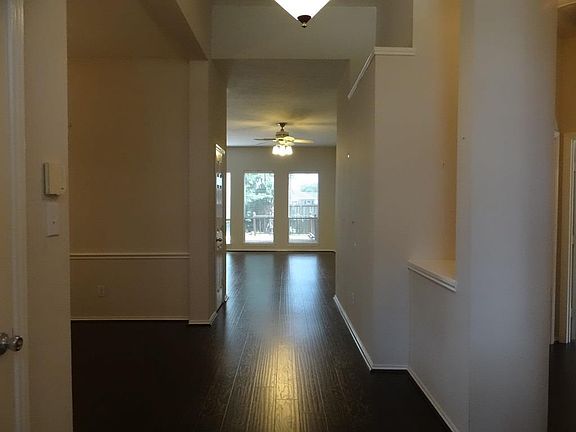 Enter your new home with wide hallway, beautiful laminate flooring, and bookshelves to your right.